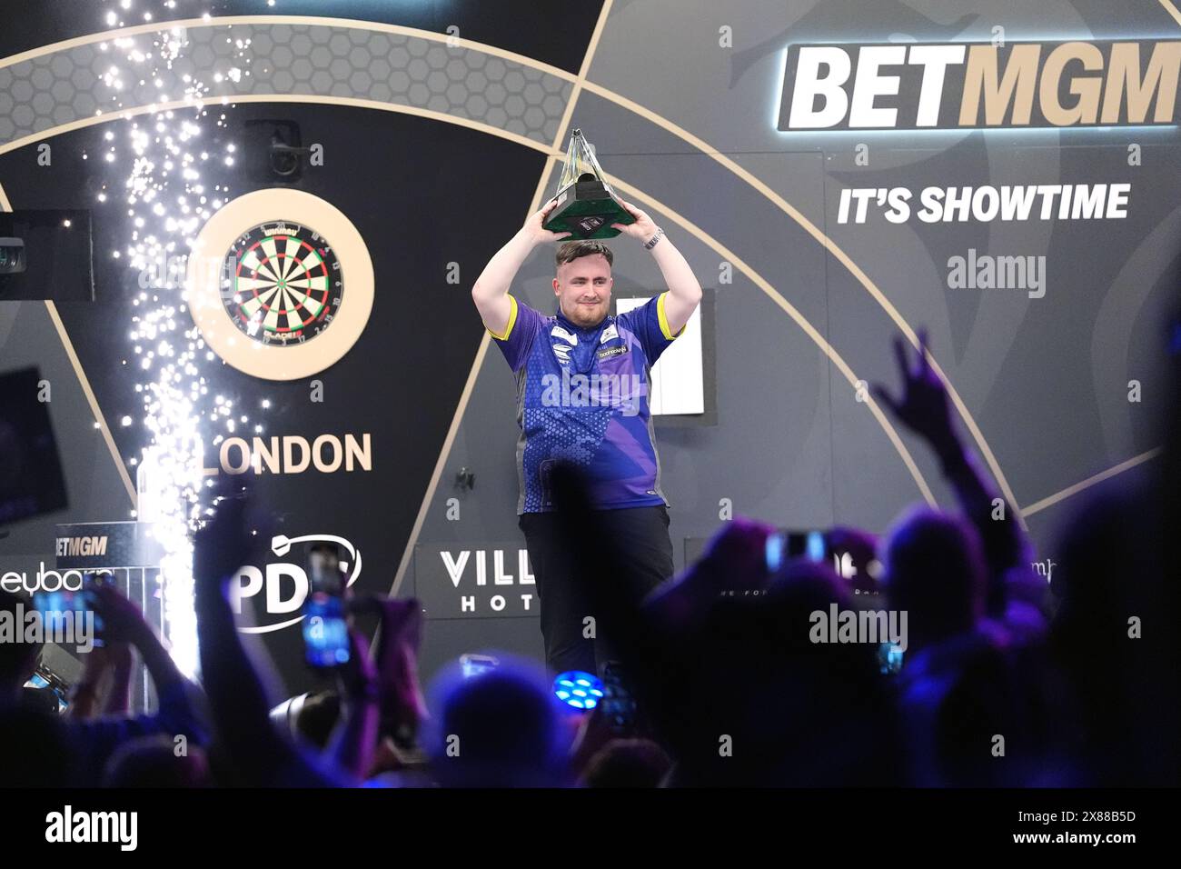 Luke Littler celebrates with the trophy after victory in the final against Luke Humphries during