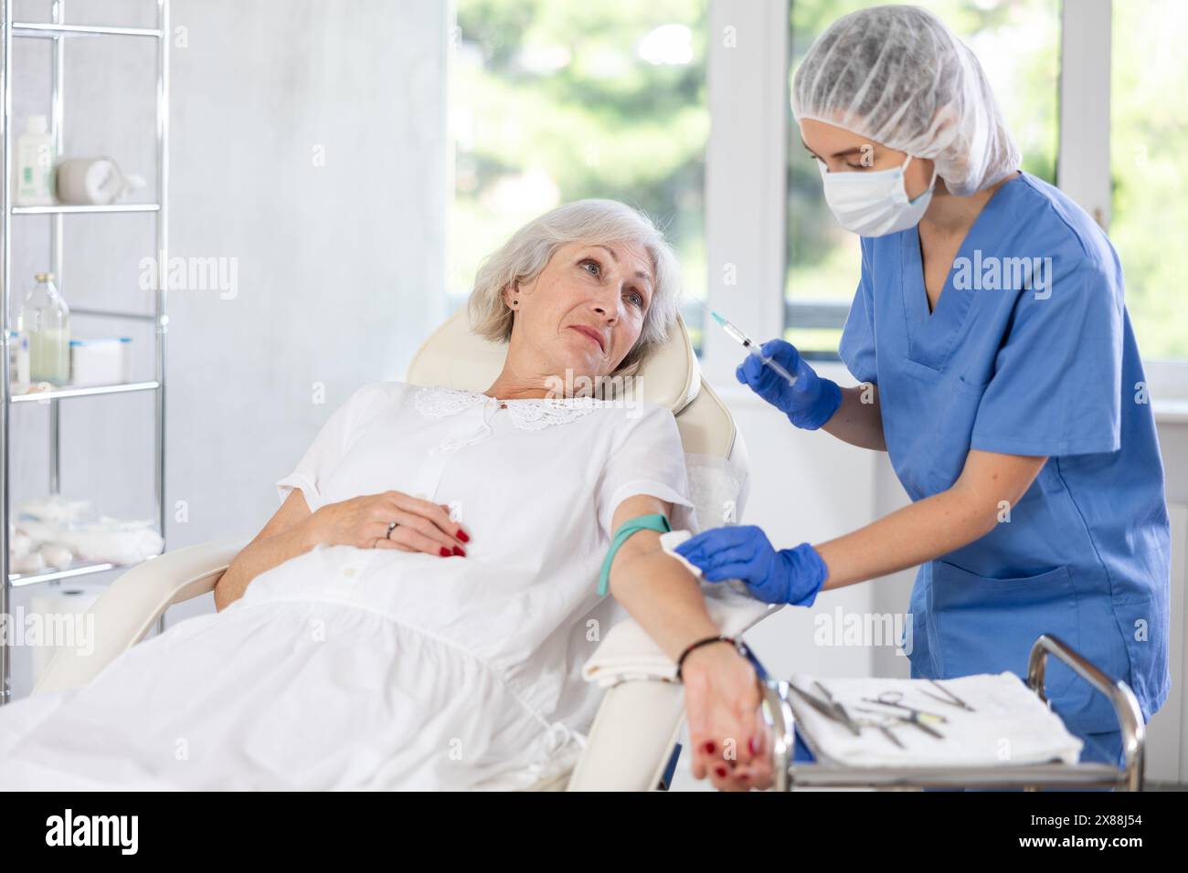 Old Practice Injection Female doctor doing injection to sleepy tired old woman in clinic Stock ...