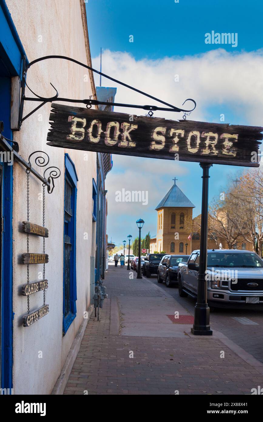 A historic building and beloved bookstore on the Plaza, Bowlins Mesilla Book Center, with wooden sign hanging at sidewalk entrance in Mesilla, NM, USA Stock Photo