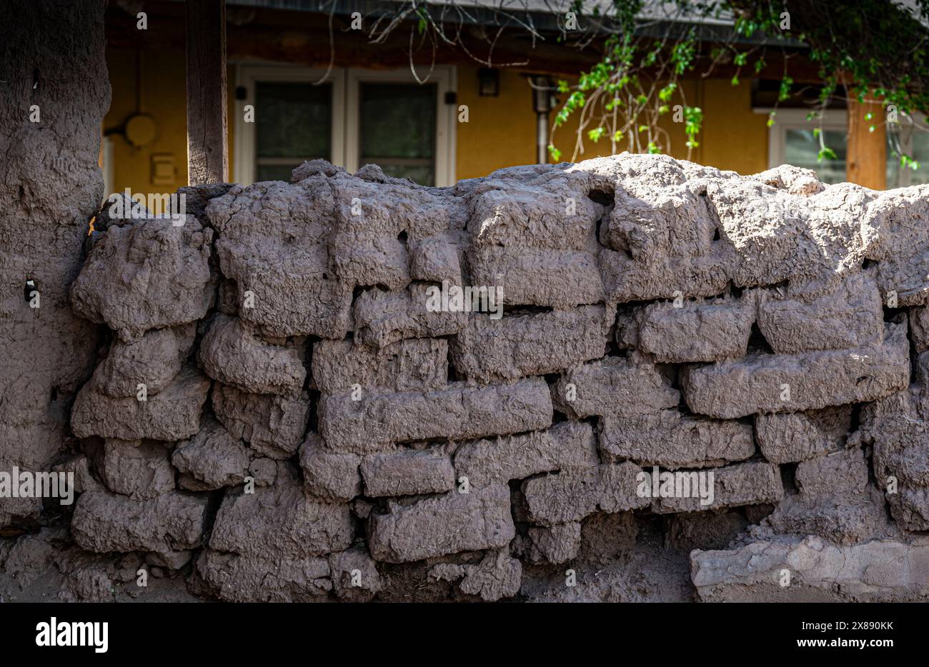 A not terribly well constructed homemade adobe brick wall, showing the rough foundation of settling adobe bricks in Southern New Mexico Stock Photo