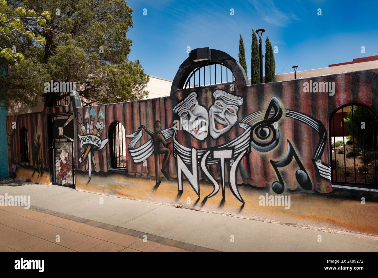The whimsical, artistic mural on walled gate, at No Strings Theater Company entrance to the black box theater in downtown Las Cruces, NM, USA Stock Photo