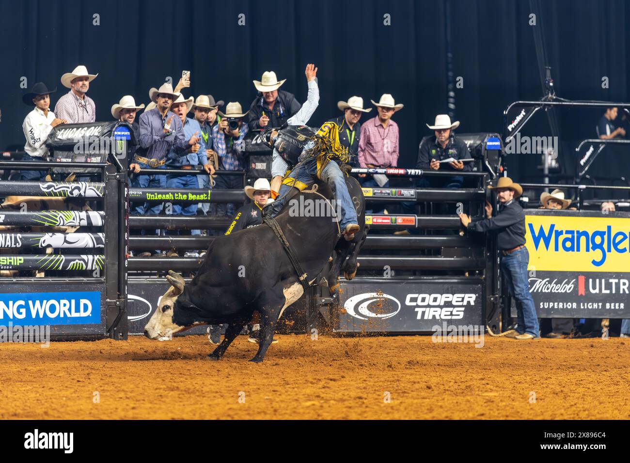 PBR World Finals 2024 in Dallas, Texas Bullfighter hanging on for eight seconds Stock Photo