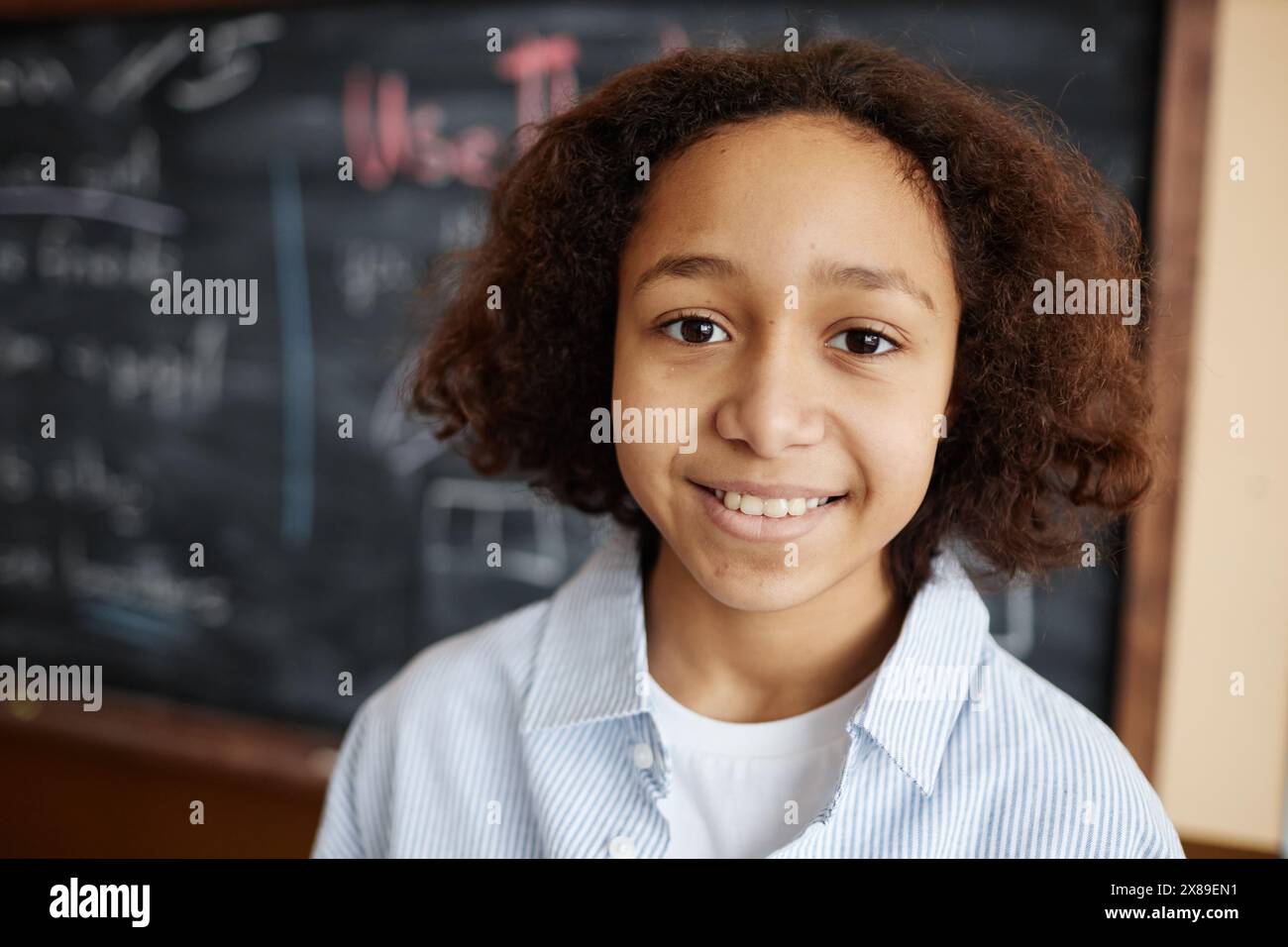 Closeup portrait of cheerful African American boy standing against ...