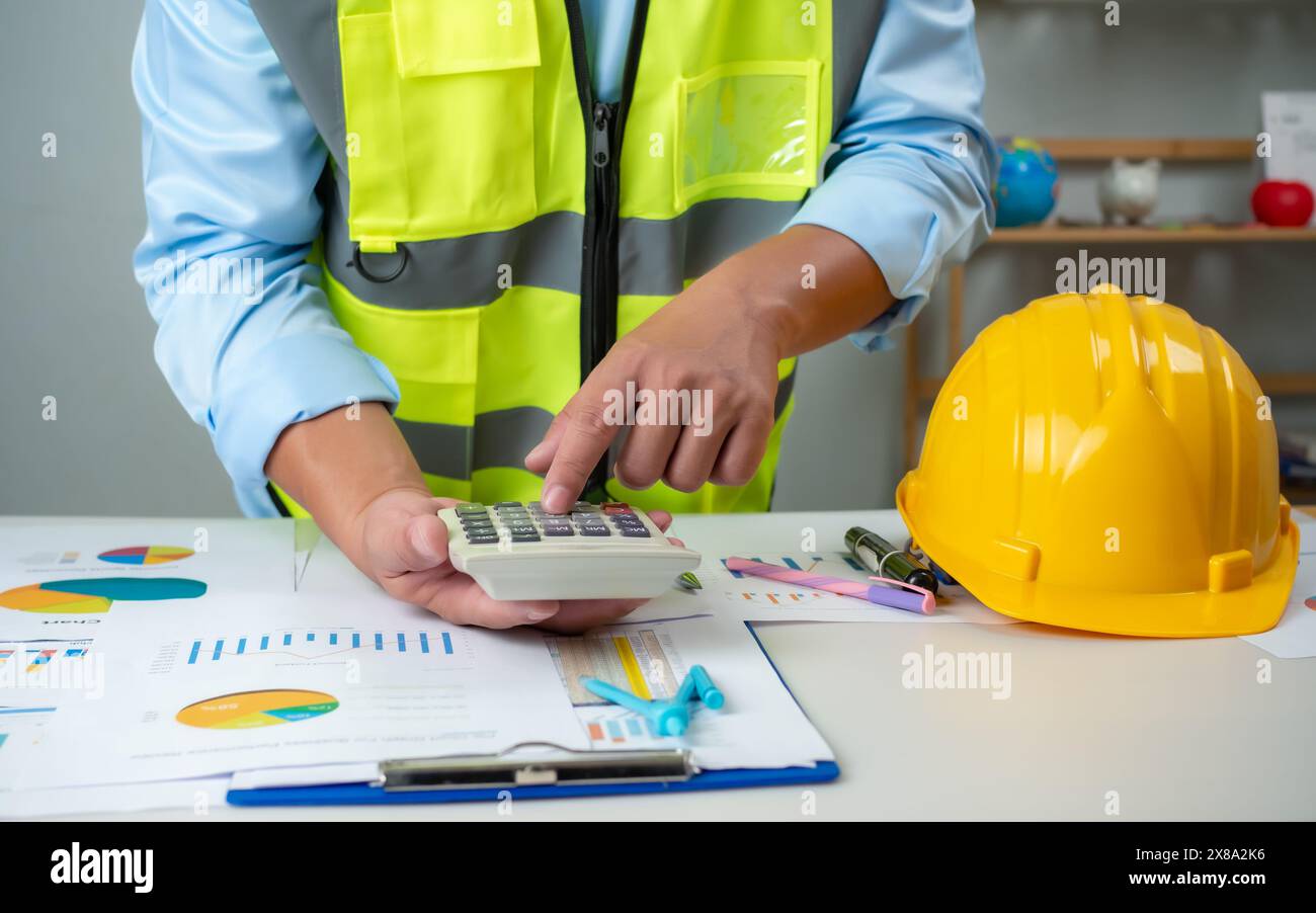 A foreman sits at a desk in an office, Calculating costs, Planning ...