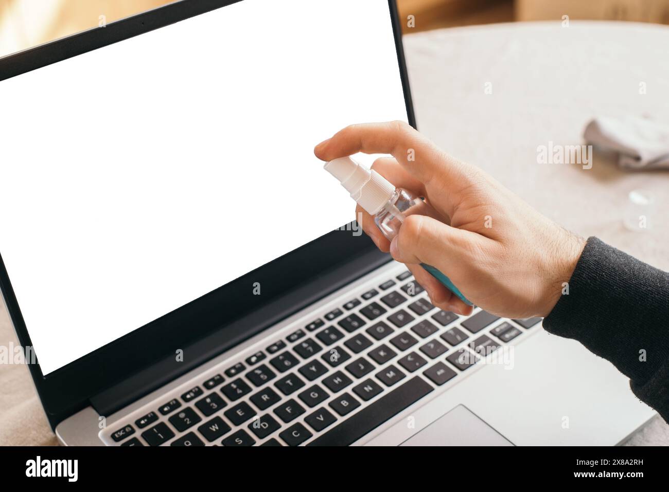 Cleaning laptop keyboard with wet wipe on working place. Personal