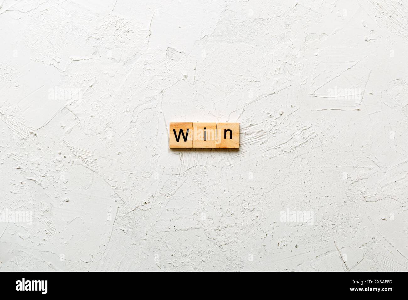 WIN word written on wood block. WIN text on cement table for your ...