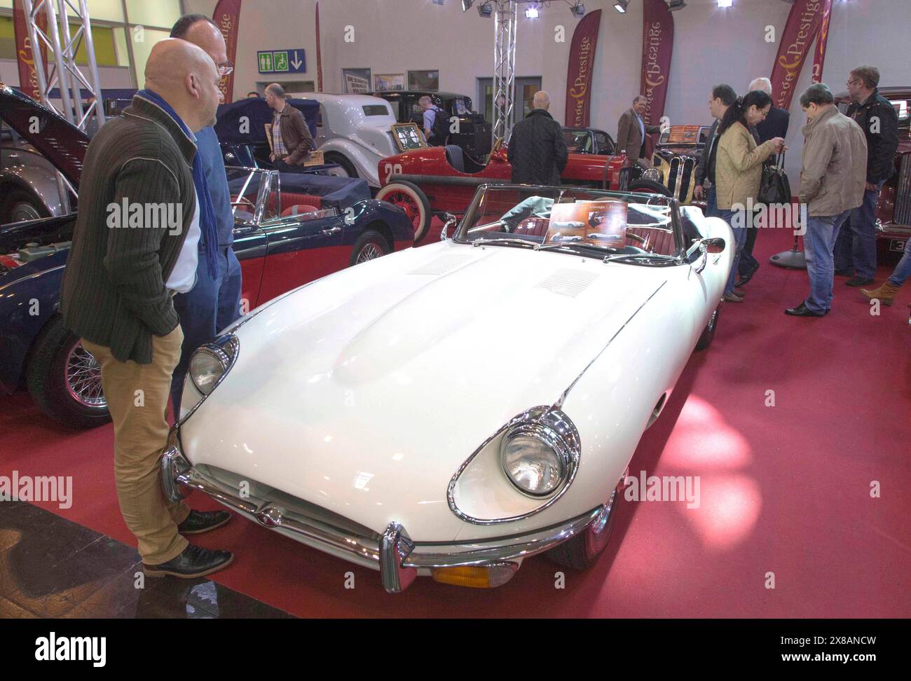 Visitors to Techno Classica take a look at a Jaguar E Type. Techno Classica is the trade fair for vintage, classic and prestige cars, motorsport, moto Stock Photo