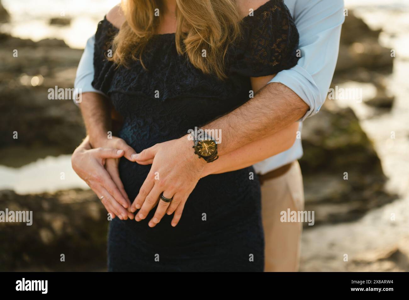 Close up of couple making heart shape with hands over baby bump Stock ...