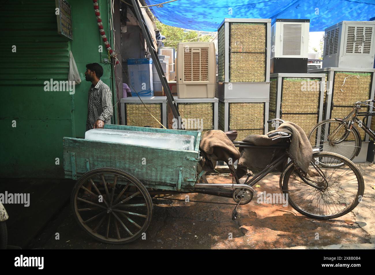 Delhi, New Delhi, India. 24th May, 2024. A worker waits for the block of ice to be loaded in a cycle rickshaw in New Delhi, inside an ice depot at a wholesale market on a hot summer day in New Delhi, India, on May 22, 2024. (Credit Image: © Deep Nair/ZUMA Press Wire) EDITORIAL USAGE ONLY! Not for Commercial USAGE! Stock Photo