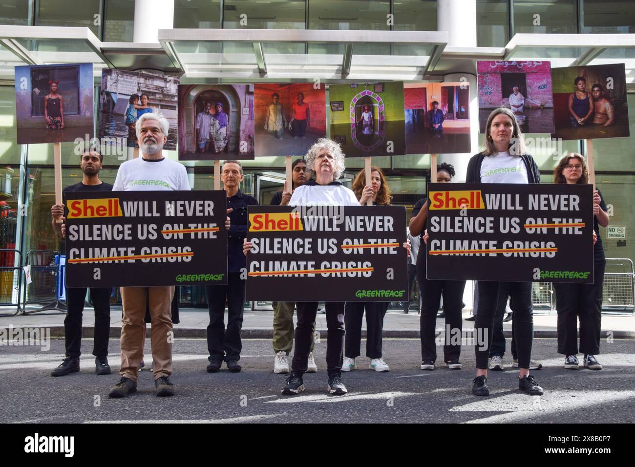 London, UK. 24th May 2024. Greenpeace activists stand with placards and photos by Gideon Mendel outside the Rolls Building as fossil fuel giant Shell takes the environmental organisation to court in response to a protest in 2023, when Greenpeace activists occupied a moving oil platform. Credit: Vuk Valcic/Alamy Live News Stock Photo