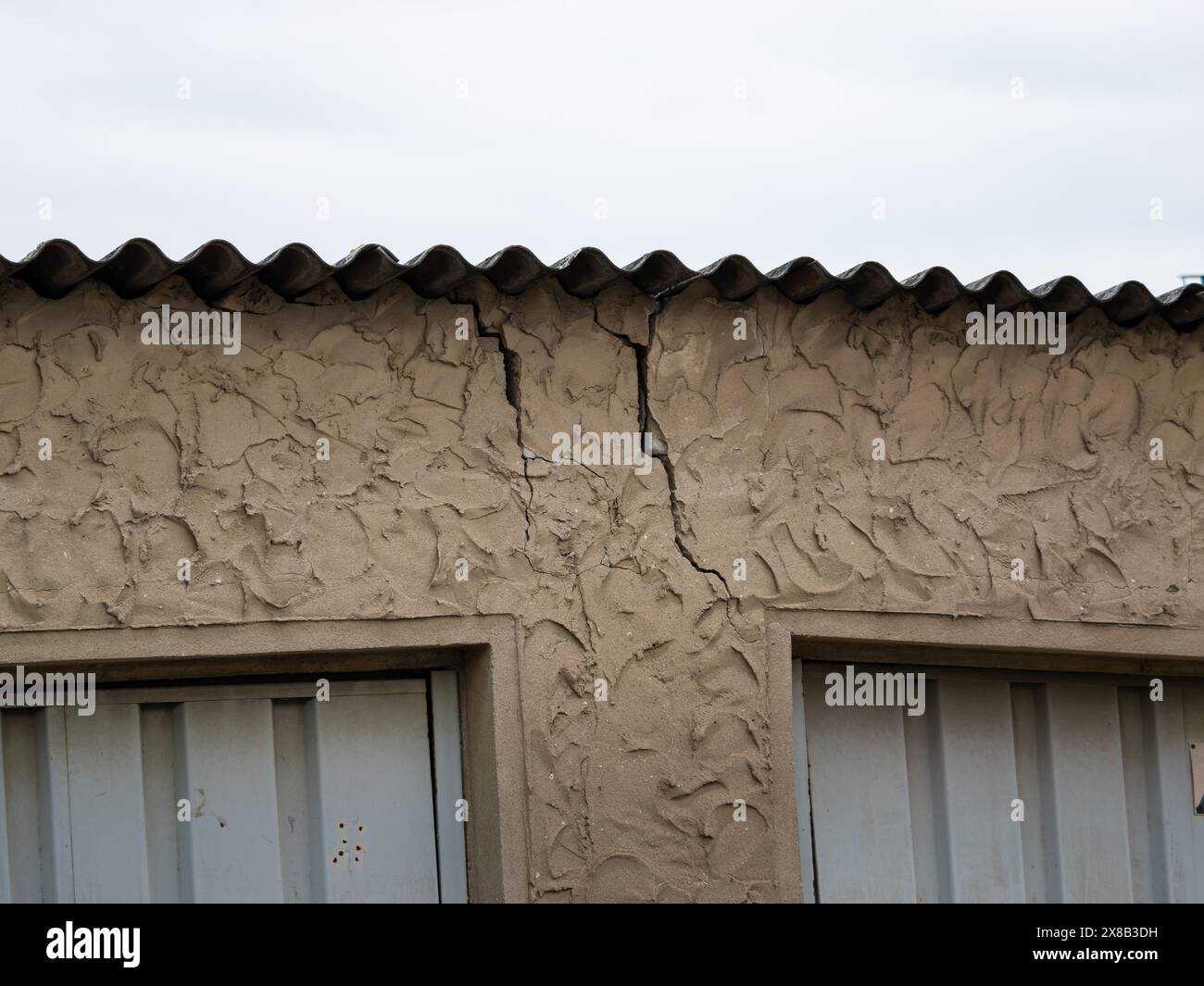 Cracks in a building wall. Constructive damage leading to a total loss of the house. The structure is broken and may collapse soon. Botched-up work. Stock Photo