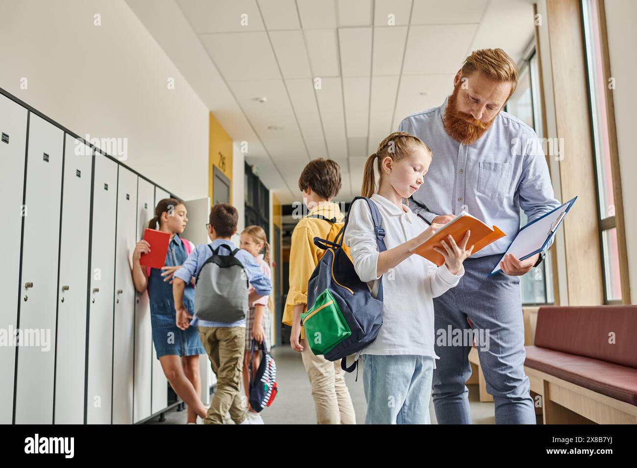 A man stands confidently next to a group of diverse kids in a hallway, engaging in mentoring or teaching activities in a bright and lively school envi Stock Photo