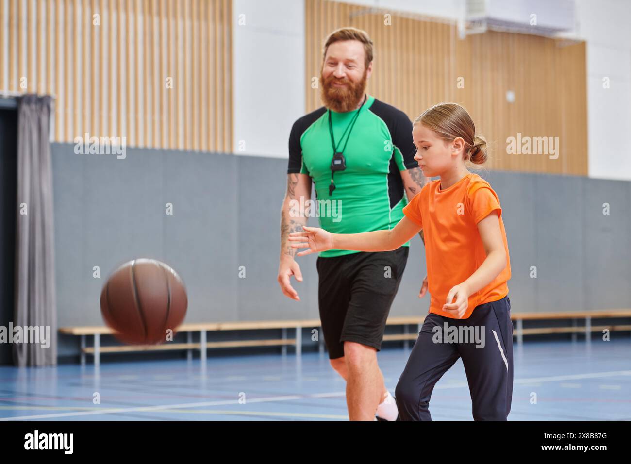 A man and a little girl are enjoying a game of basketball together. Stock Photo