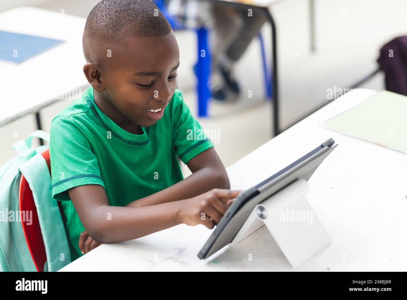 In school, young African American boy using a tablet in the classroom Stock Photo