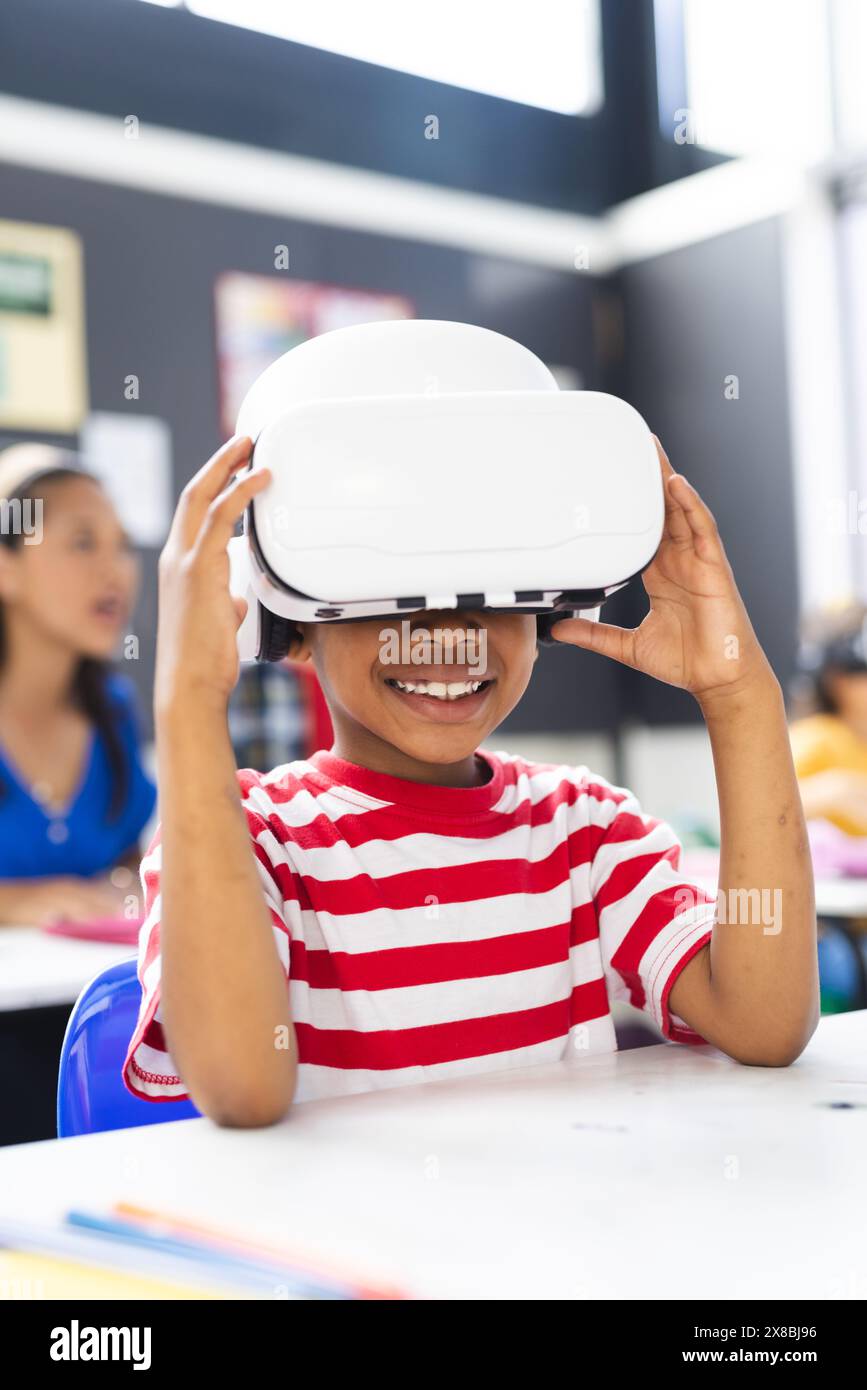In school, young African American boy wearing a VR headset smiles in the classroom Stock Photo