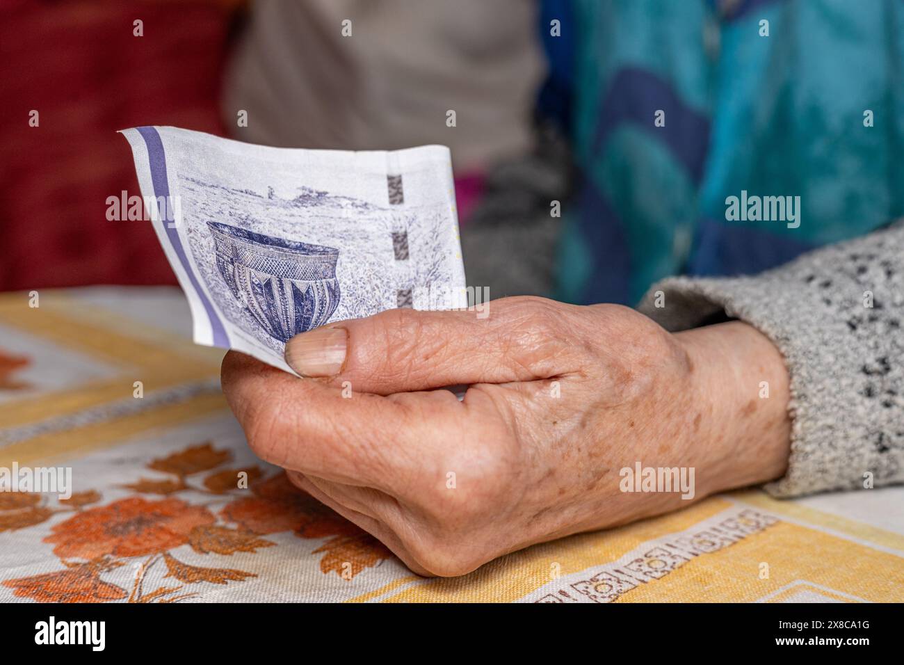 Elderly woman clutches a 50 Danish kroner banknote in her hand, Concept, Denmark finances of elderly people, close up Stock Photo