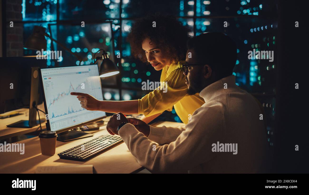 Small Creative Multicultural Team Collaborate on a Project and Work Together as a Team. Project Manager and Software Developer Talking and Discussing Changes to Document. Evening at Work. Stock Photo