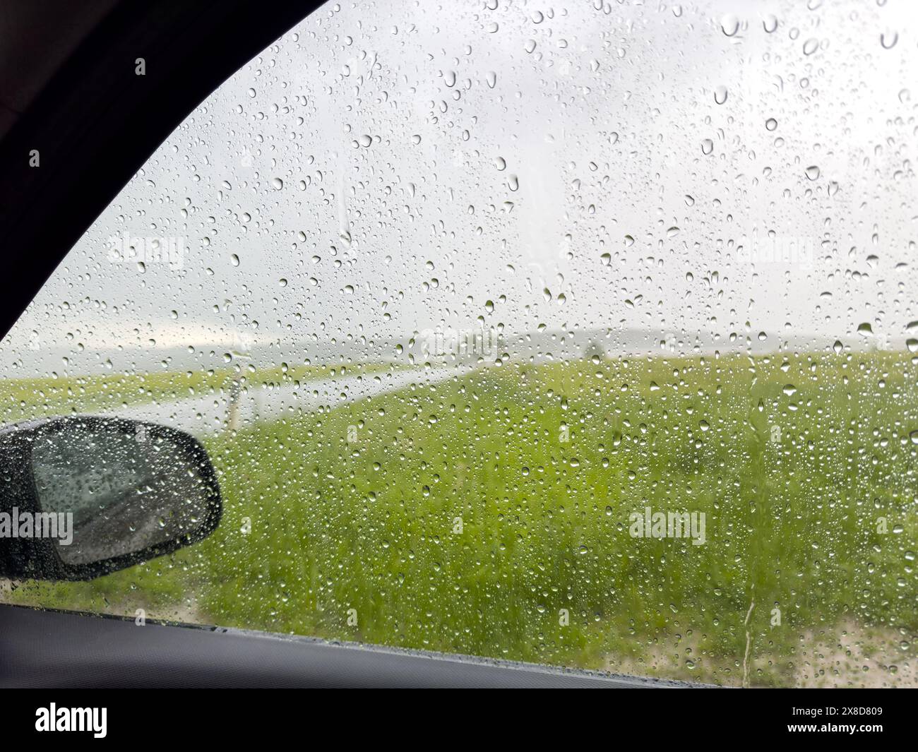 Side window of a car with raindrops during a storm Stock Photo
