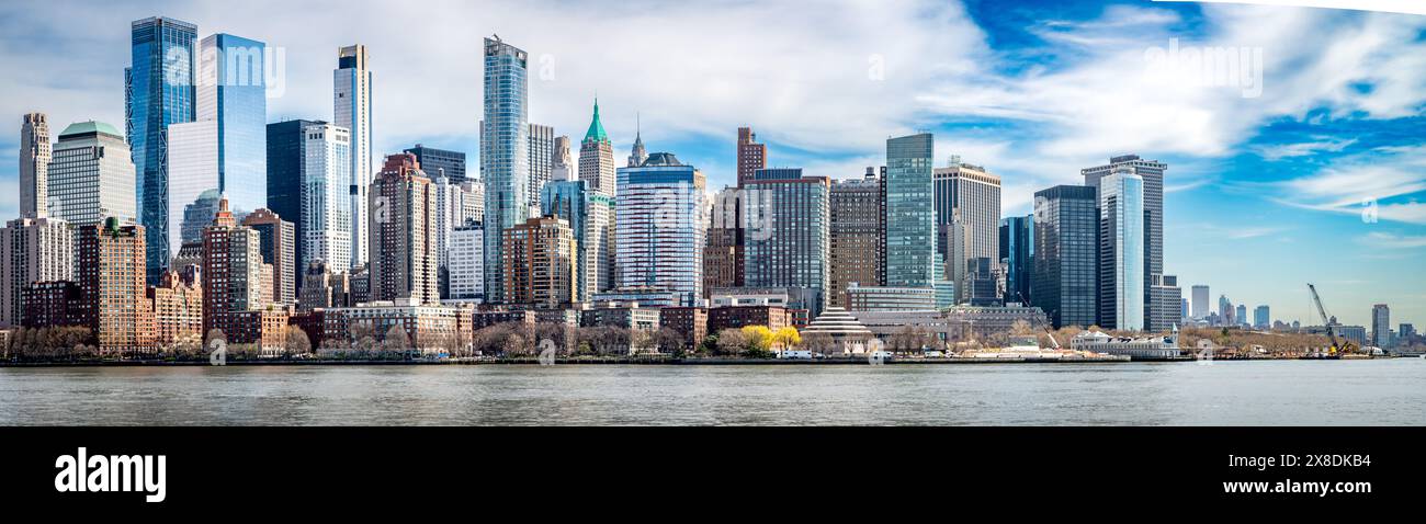 Witness the awe-inspiring panorama of New York City from the tranquil waters of the Hudson River. Iconic skyscrapers pierce the twilight sky. Stock Photo