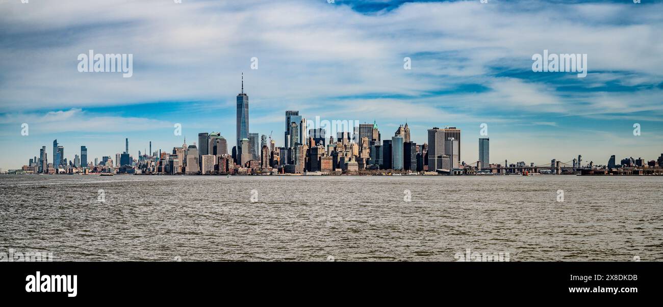 Witness the awe-inspiring panorama of New York City from the tranquil waters of the Hudson River. Iconic skyscrapers pierce the twilight sky. Stock Photo