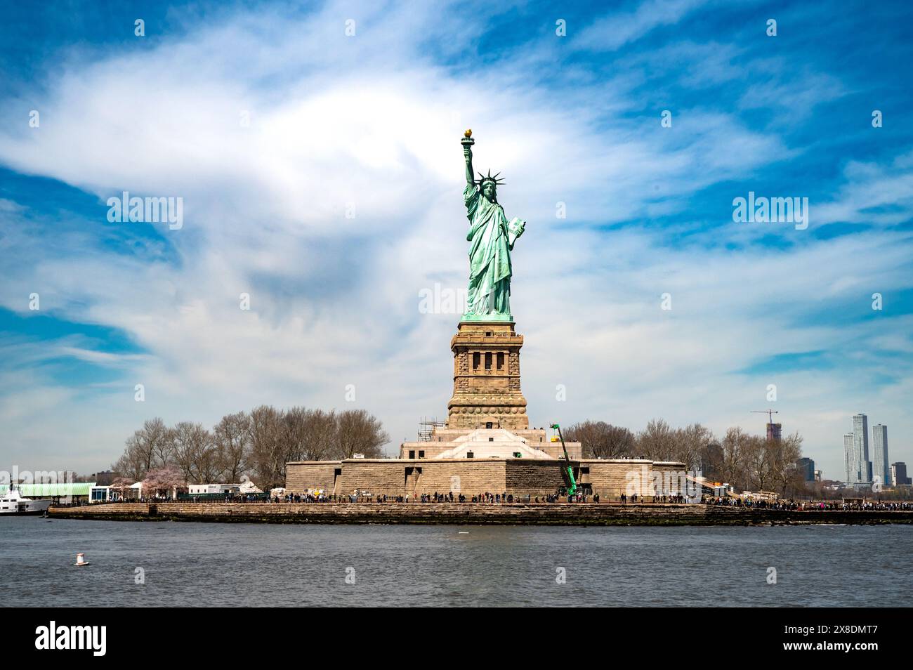 Lady Liberty lights the way! Capture the iconic symbol of freedom, her torch held high against a clear blue sky. Ideal for travel and history content. Stock Photo