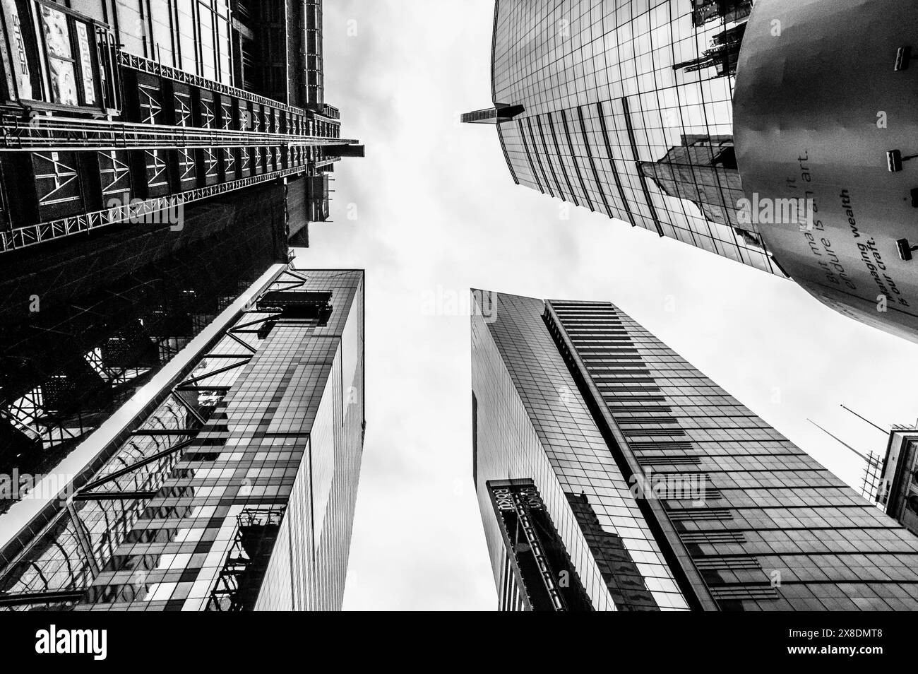 NYC giants reach for the sky! Towering Manhattan buildings dwarf pedestrians on bustling streets. Classic scene for travel and urban life content. Stock Photo