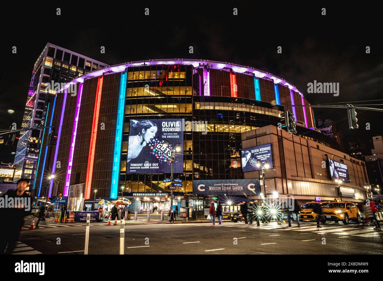 New York, New York, United States - 04 08 2024: NYC's energy hub at night! Buzzing crowds navigate Madison Square Garden. Stock Photo