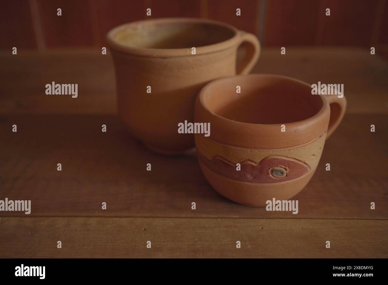 Empty earthenware mug on wooden table background. Stock Photo