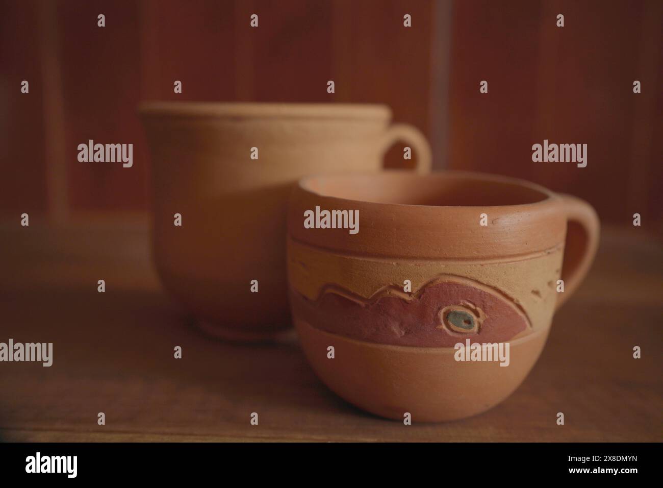 Empty earthenware mug on wooden table background. Stock Photo