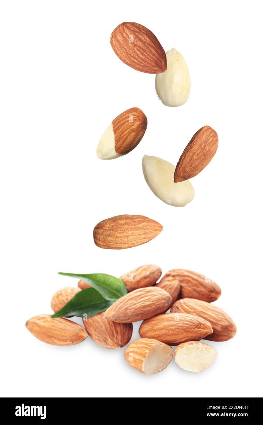 Many fresh almonds falling on white background Stock Photo