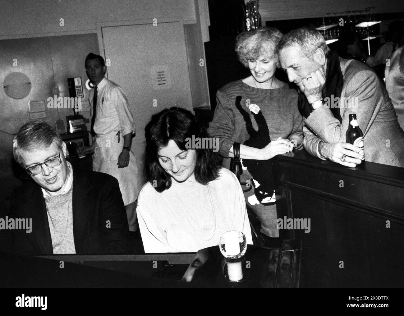 PAUL NEWMAN(R) AND WIFE JOANNE WOODWARD LISTEN TO PIANO PLAYERS AT A PRIVATE PARTY FOR GLASS MENEGERIE AT WILSON'S RESTAURANT.©JUDIE BURSTEIN/ PAULNEWMANRETRO.(Credit Image: © JUDIE BURSTEIN/ZUMA Wire) EDITORIAL USAGE ONLY! Not for Commercial USAGE! Stock Photo