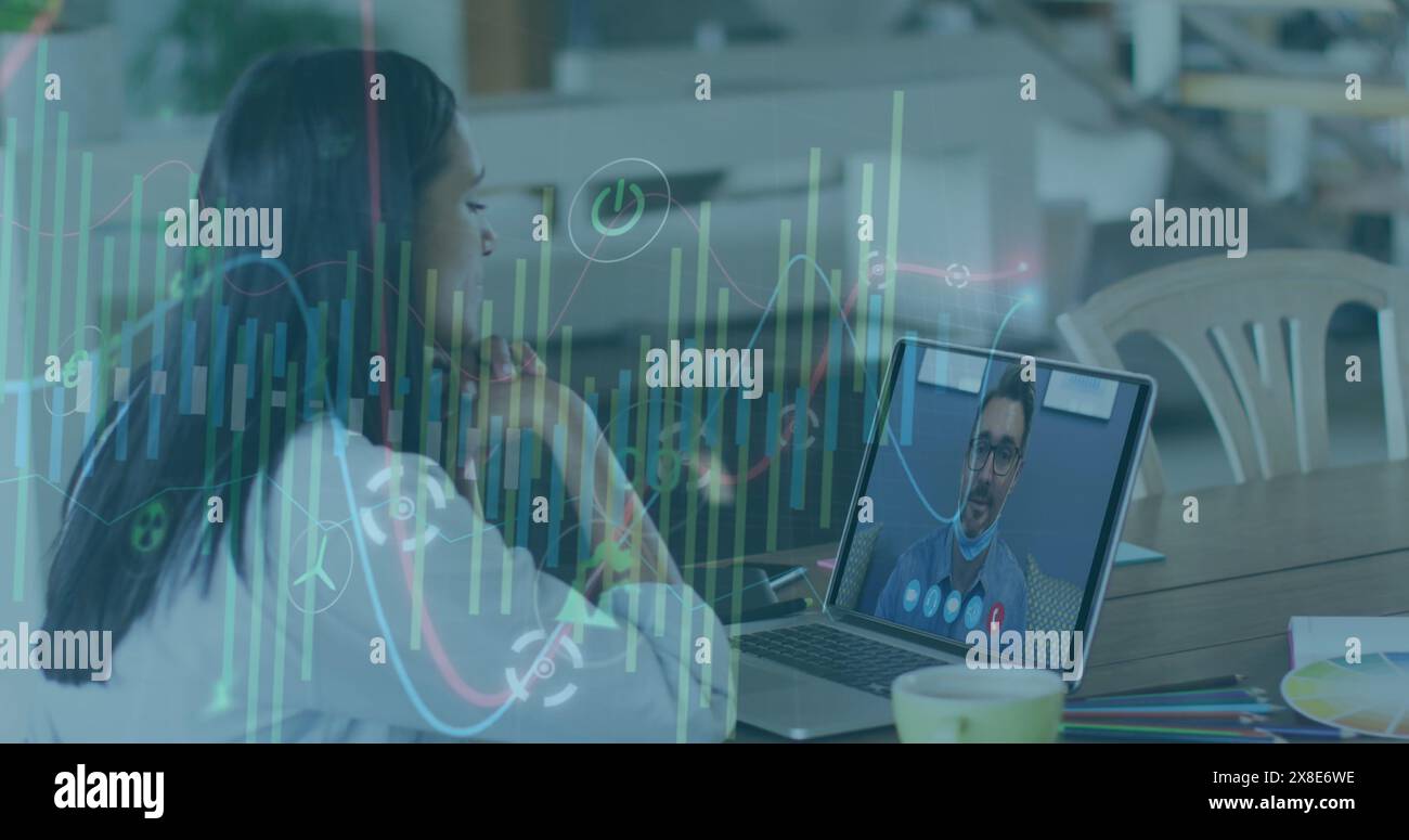 Biracial colleague, wearing white blouse, discussing with Caucasian boss on laptop Stock Photo