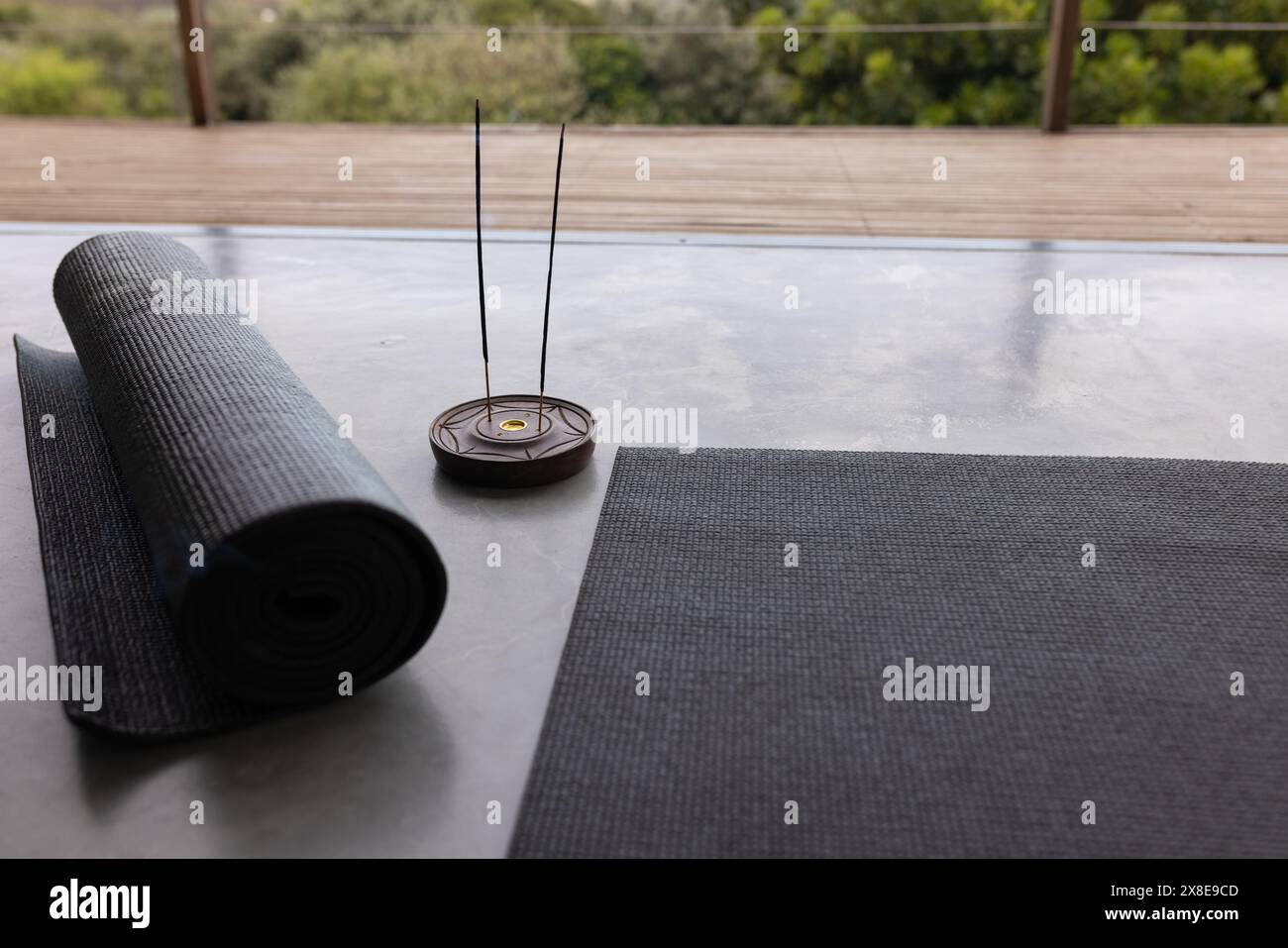 At home, yoga mat and incense burner resting on a sleek surface Stock Photo