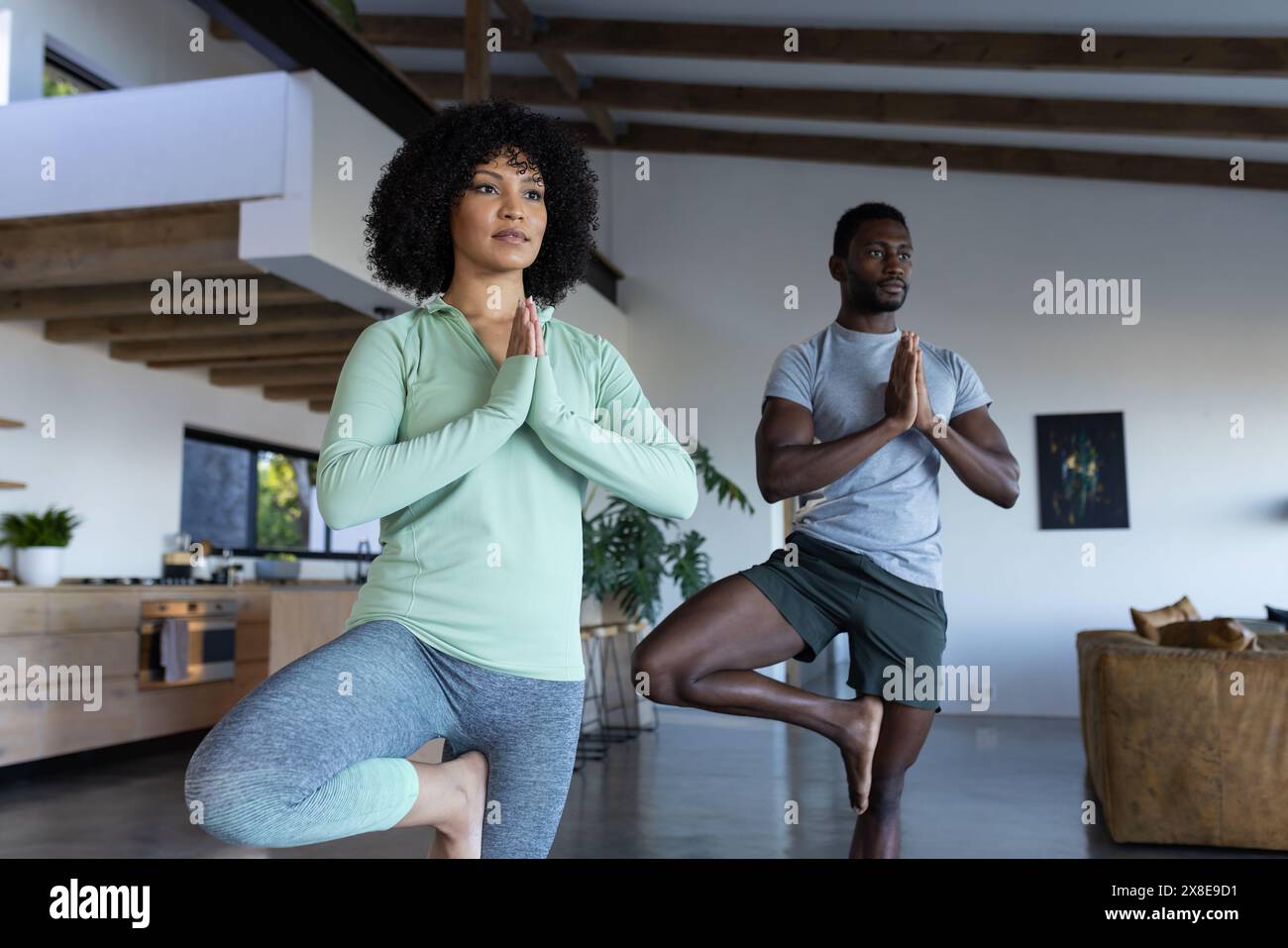 A diverse couple practicing yoga together at home Stock Photo