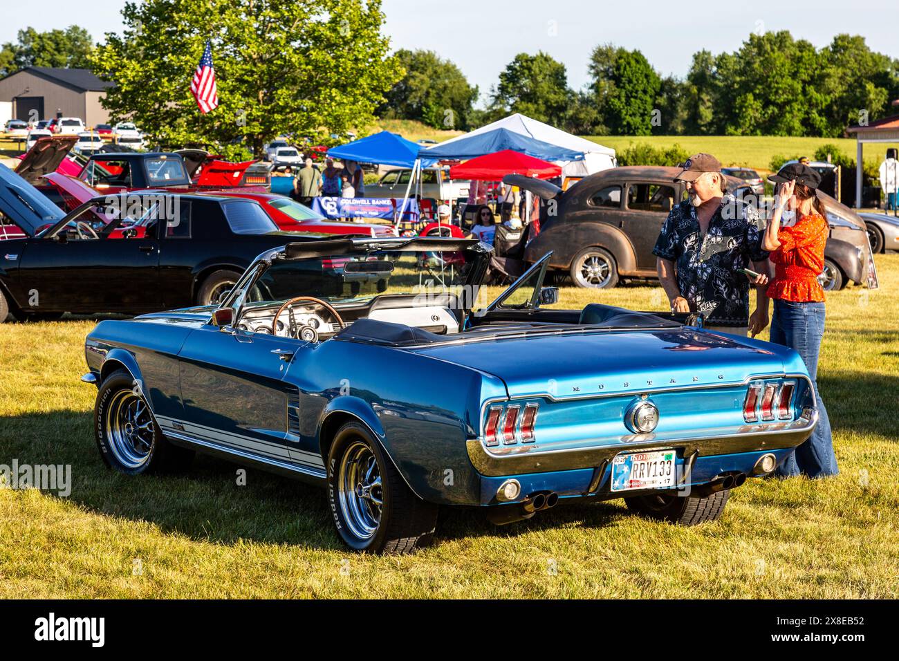A blue 1967 Ford Mustang convertible on display at car show at