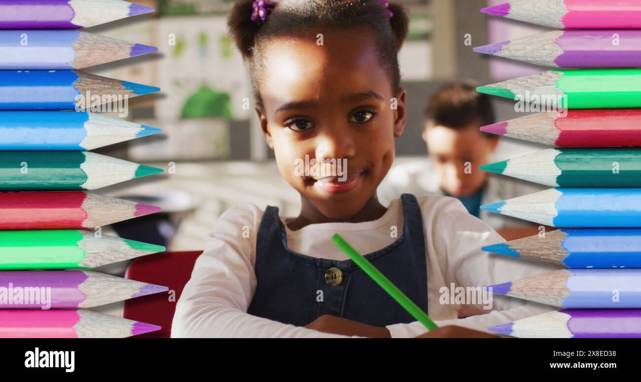 African American girl with green pencil, Caucasian boy behind in school Stock Photo