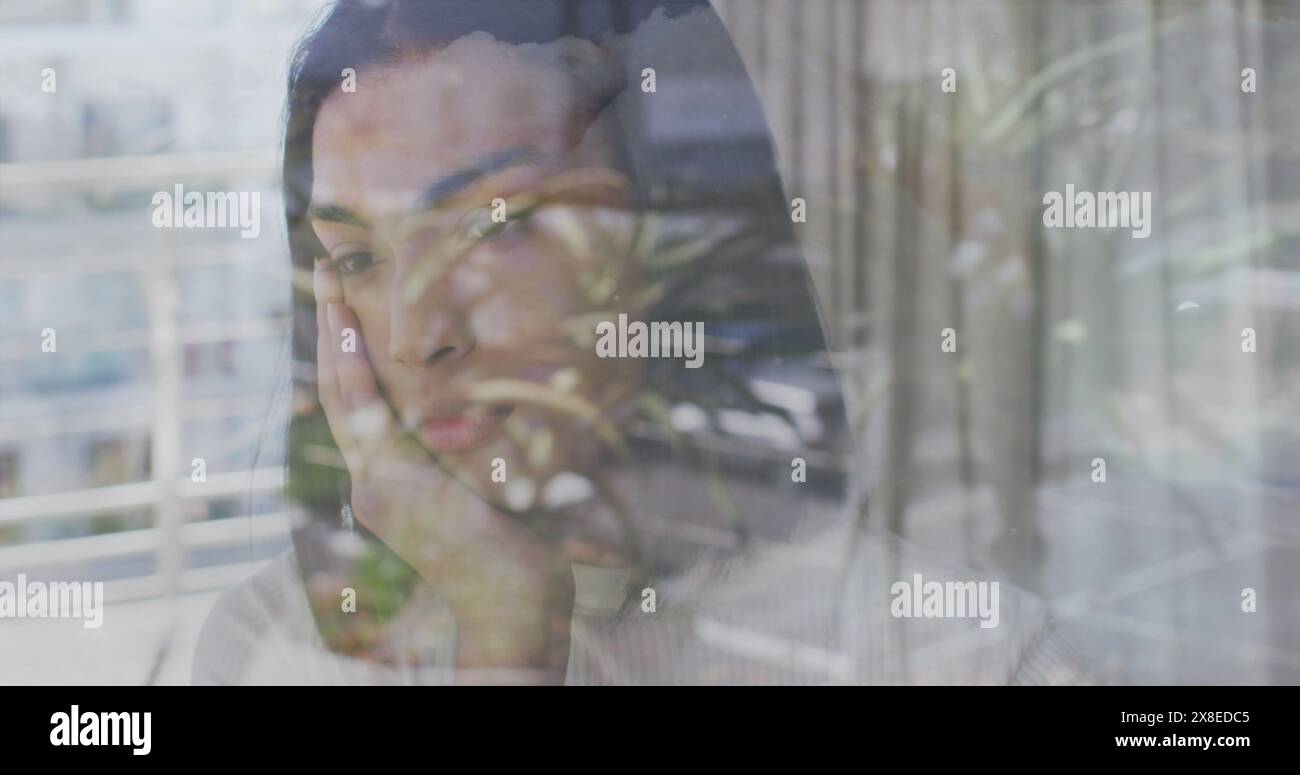 Young Asian woman standing behind window, blending with reflections Stock Photo