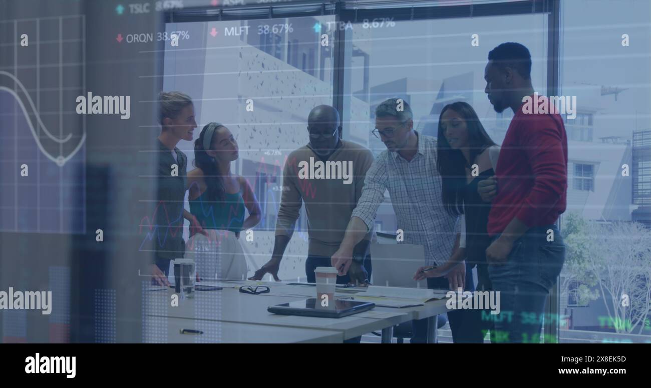 Image of stock market data processing over diverse colleagues discussing together at office Stock Photo