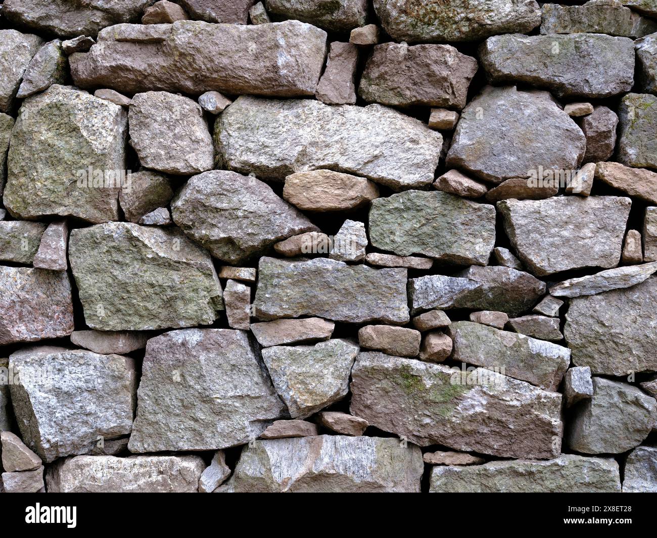 Front view close up section of a stone wall construction without cement Stock Photo