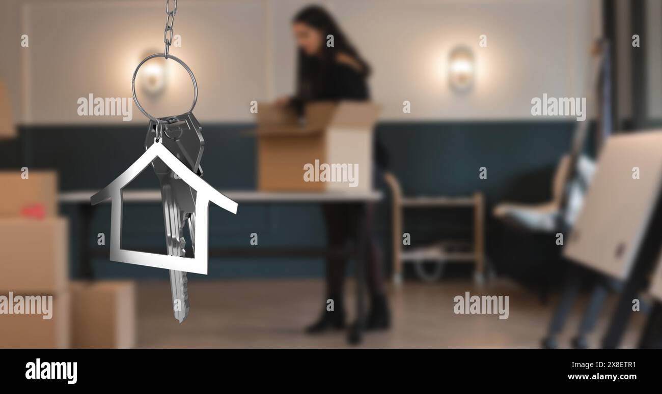 Image of hanging golden house keys against blurred view of woman unpacking boxes Stock Photo