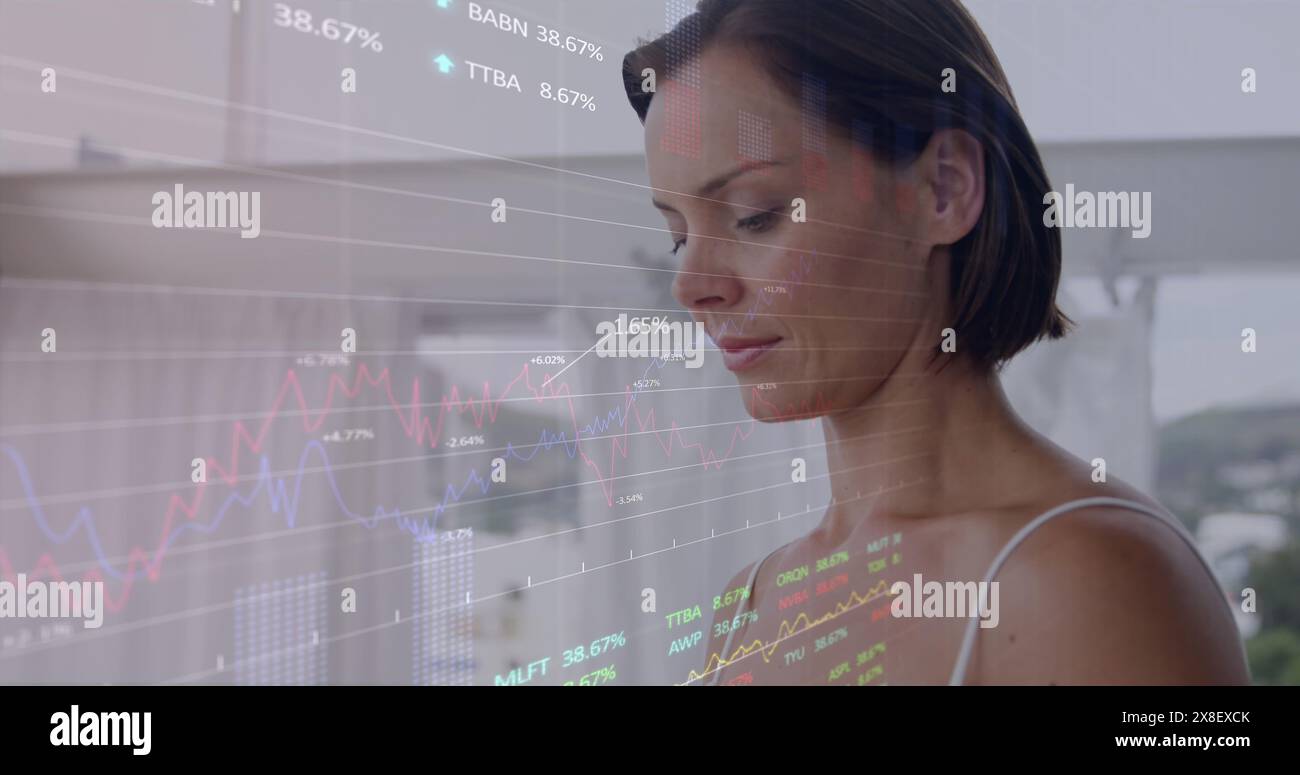 Image of stock market data processing over caucasian woman using digital tablet at home Stock Photo