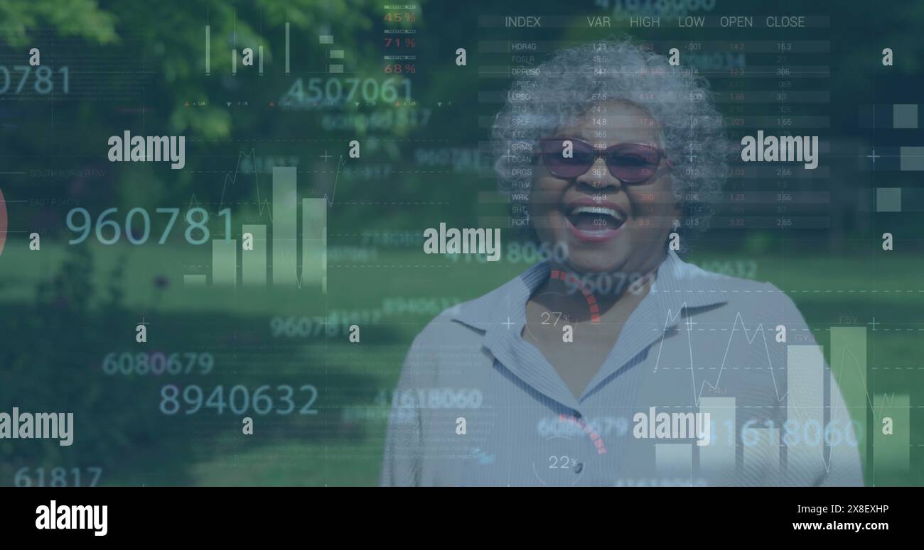 Image of numbers, infographic interface, laughing senior biracial woman standing outdoors Stock Photo