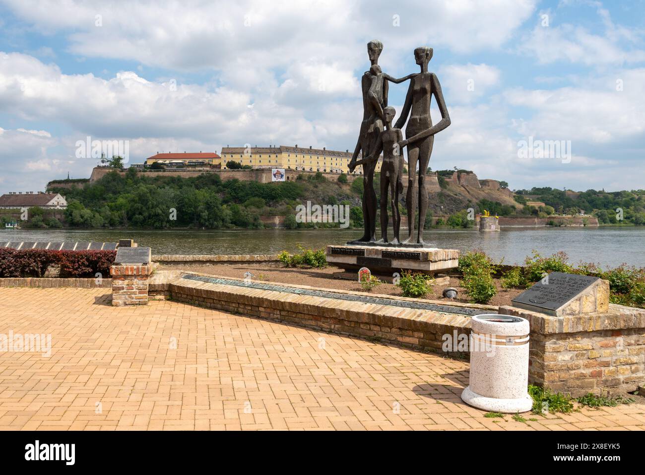 Memorial to WW2 victims on the Danube waterfront with Petrovaradin fortress behind on the opposite bank. April 2024. Stock Photo