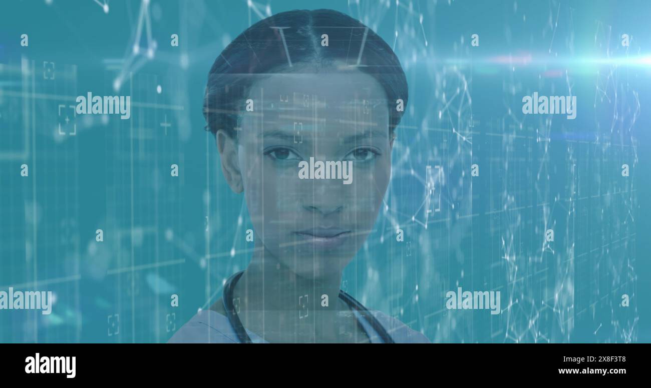 African American woman standing in front of digital screens, wearing simple top Stock Photo