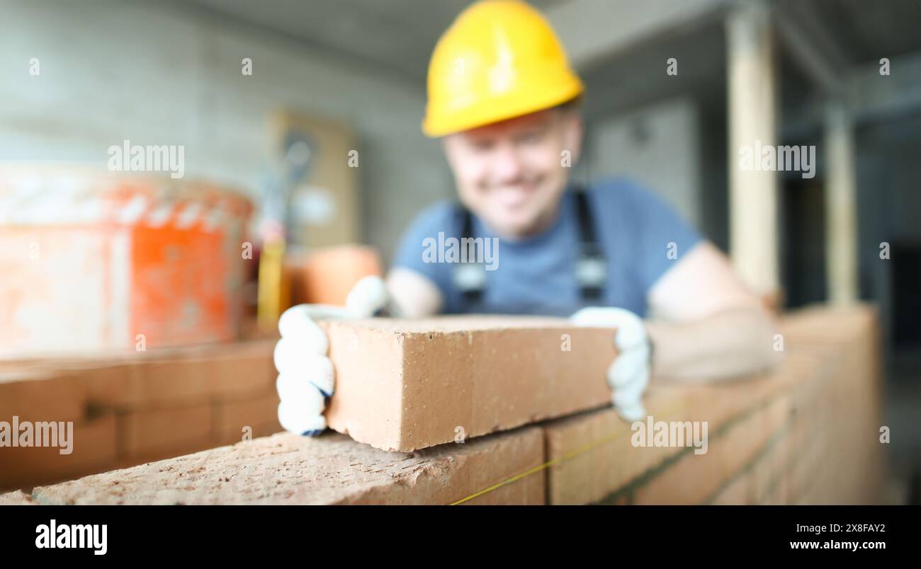 Male smiling builder puts make brickwork Stock Photo - Alamy