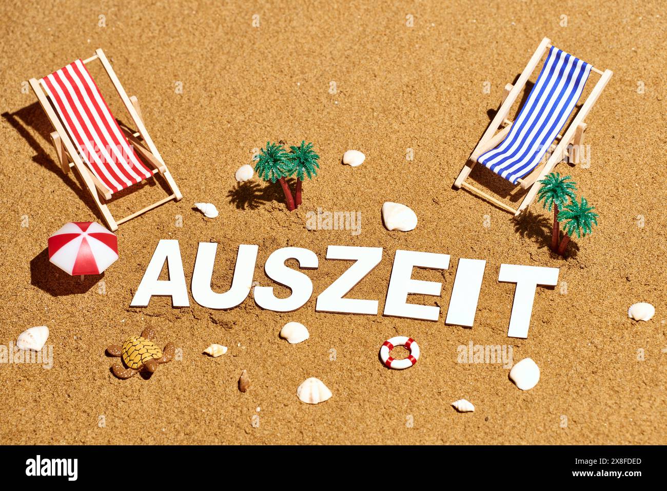 Lido di Jesolo, Italy - 3 May 2024: Lettering: Time out, in the sand on the beach with sun loungers and parasols *** Schriftzug: Auszeit, im Sand am Strand mit Sonnenliegen und Sonnenschirmen Stock Photo