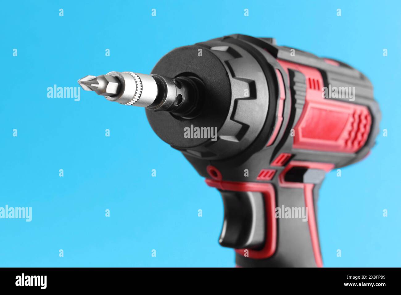 Modern electric screwdriver on light blue background, closeup. Space for text Stock Photo