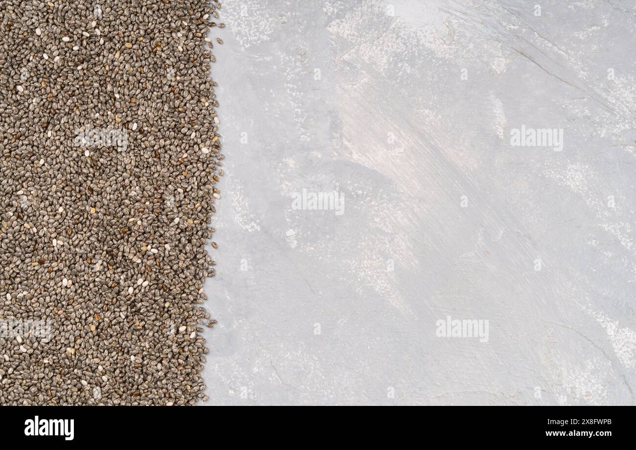 Scattered chia seeds on empty concrete background, top view. Copy space Stock Photo