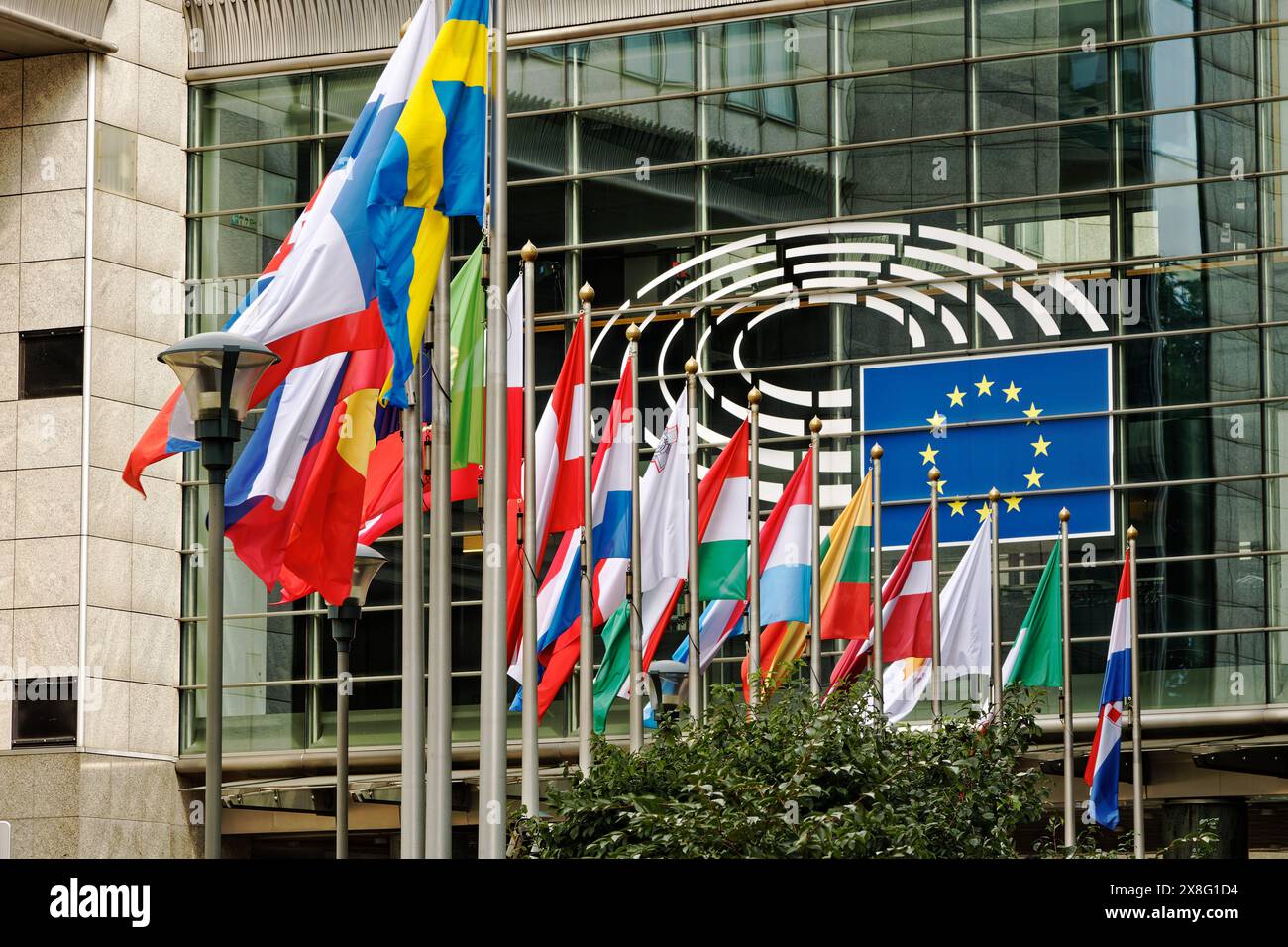 The seat of the European Parliament. Architecture and glass facades in a place where European and global cultures meet. Peace flags waving euro statue Stock Photo