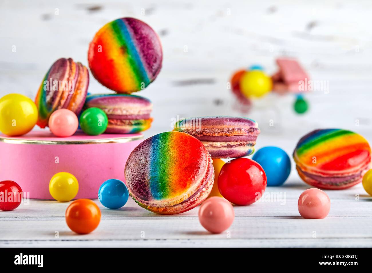 The table is filled with a variety of candies and gums, showcasing a variety of rainbow macaron flavors and textures to satisfy any sweet tooth. Stock Photo